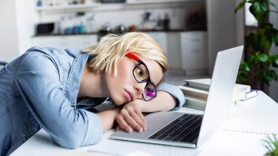 blonde haired employee with adhd bored at a computer