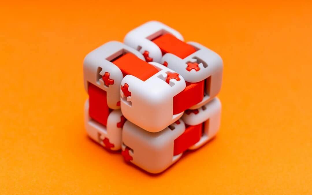 white and red fidget cube on an orange background