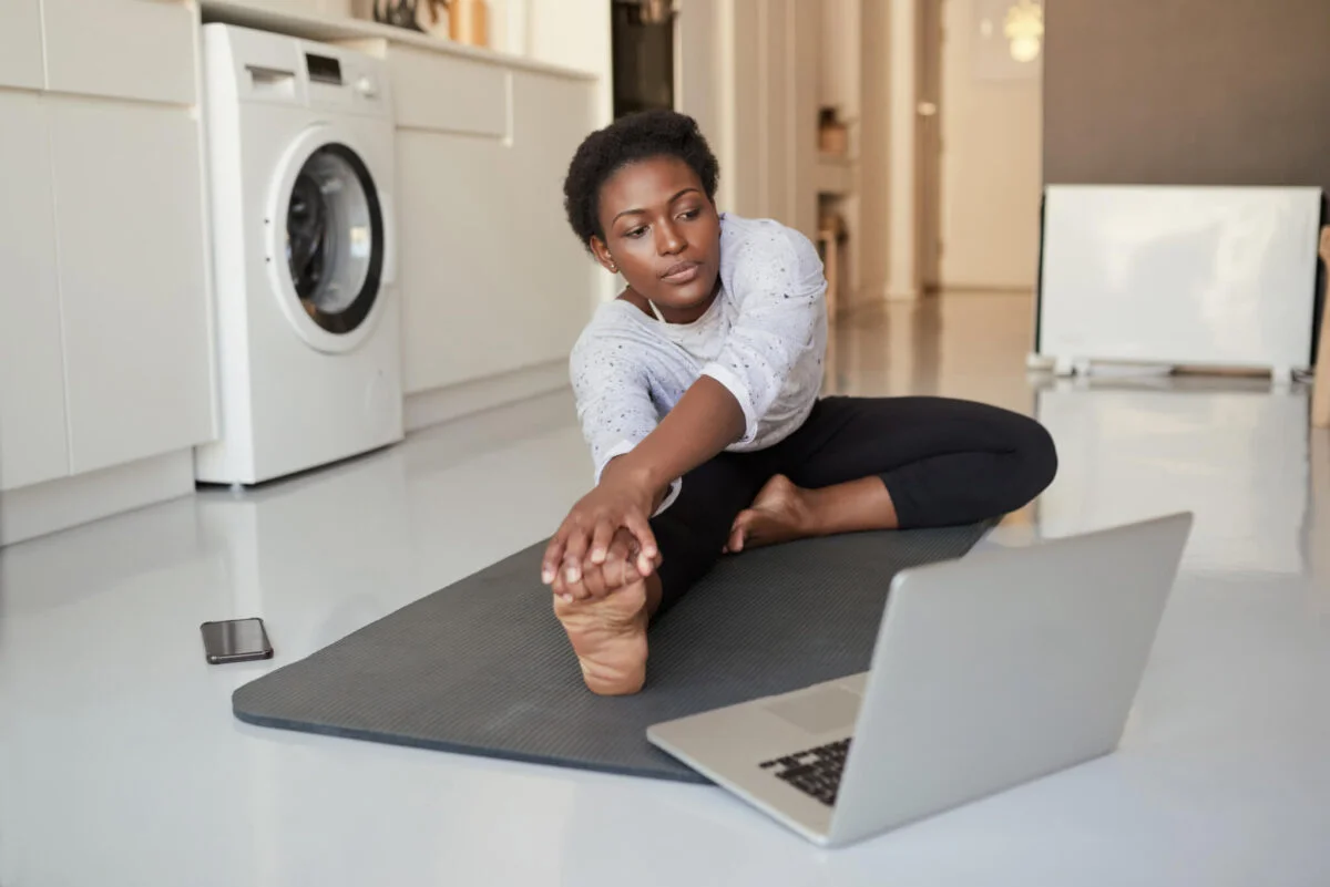 woman exercising at home doing yoga while working