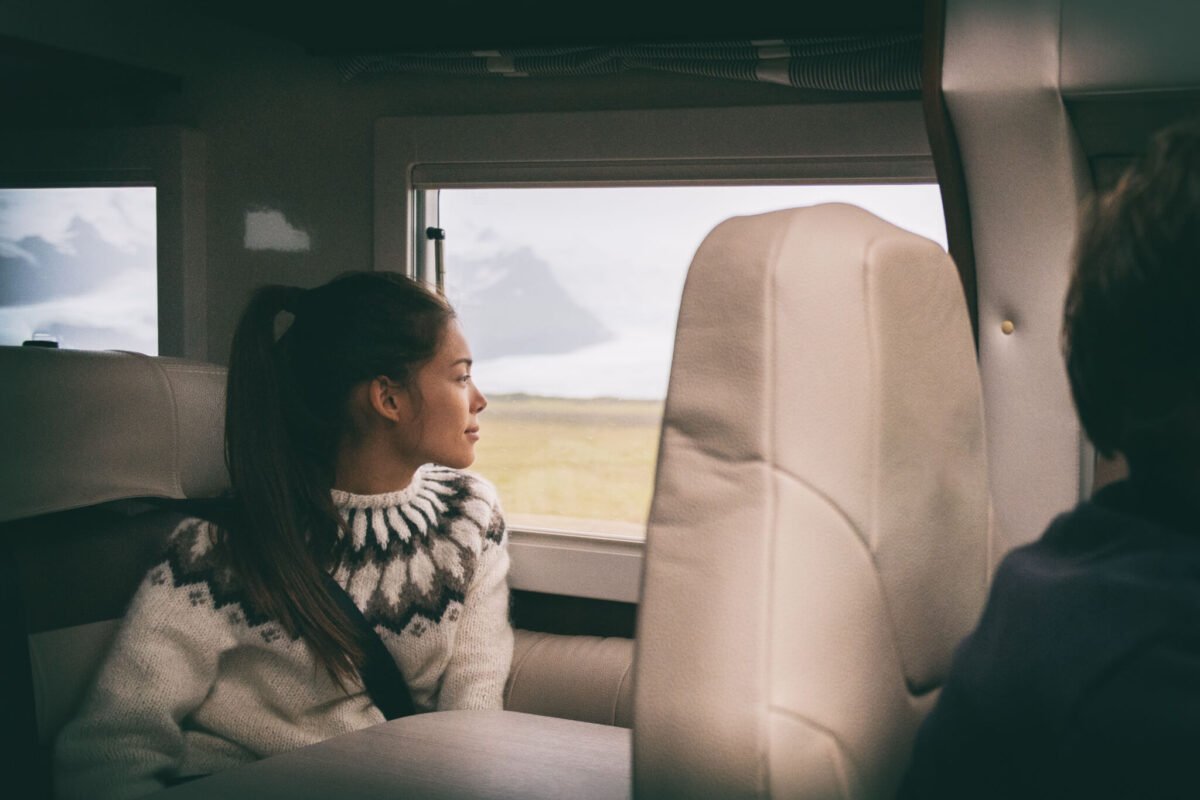 Asian girl relaxing in motorhome on long journey
