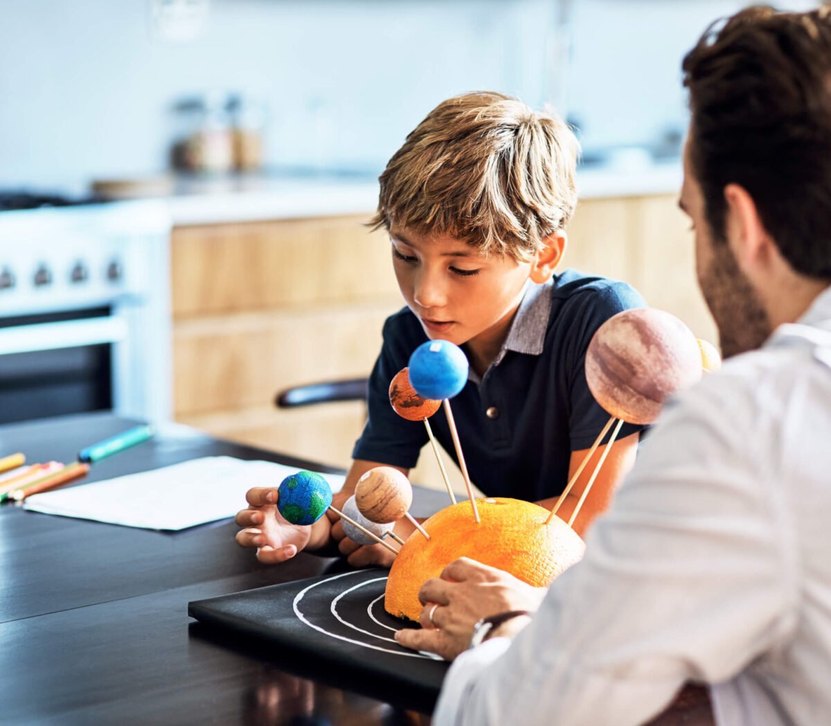 young boy and his dad learning about science and planets at home