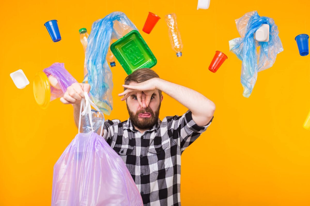 man holding nose while taking trash out 