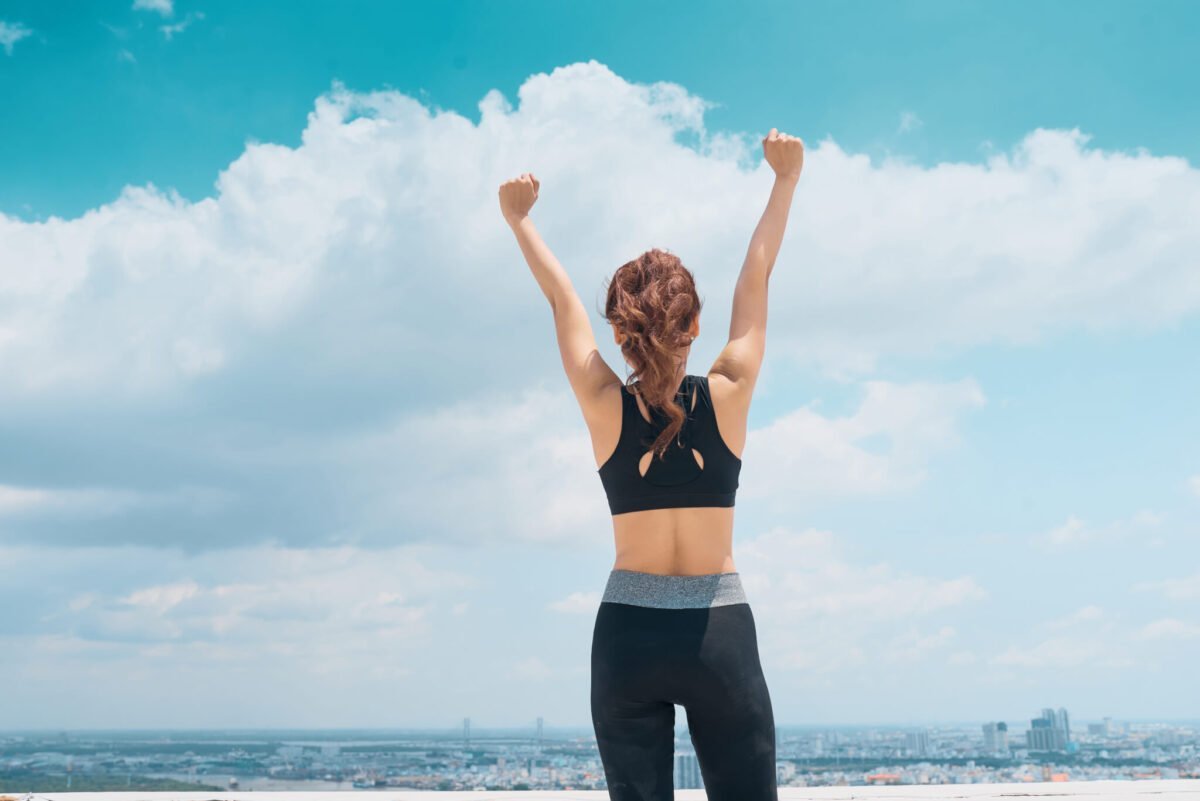 woman facing the sky with fists in air celebrating