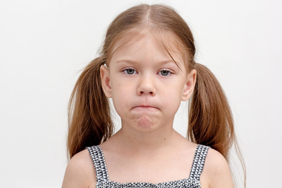 young girl frustrated with pursed lips and hair in pigtails