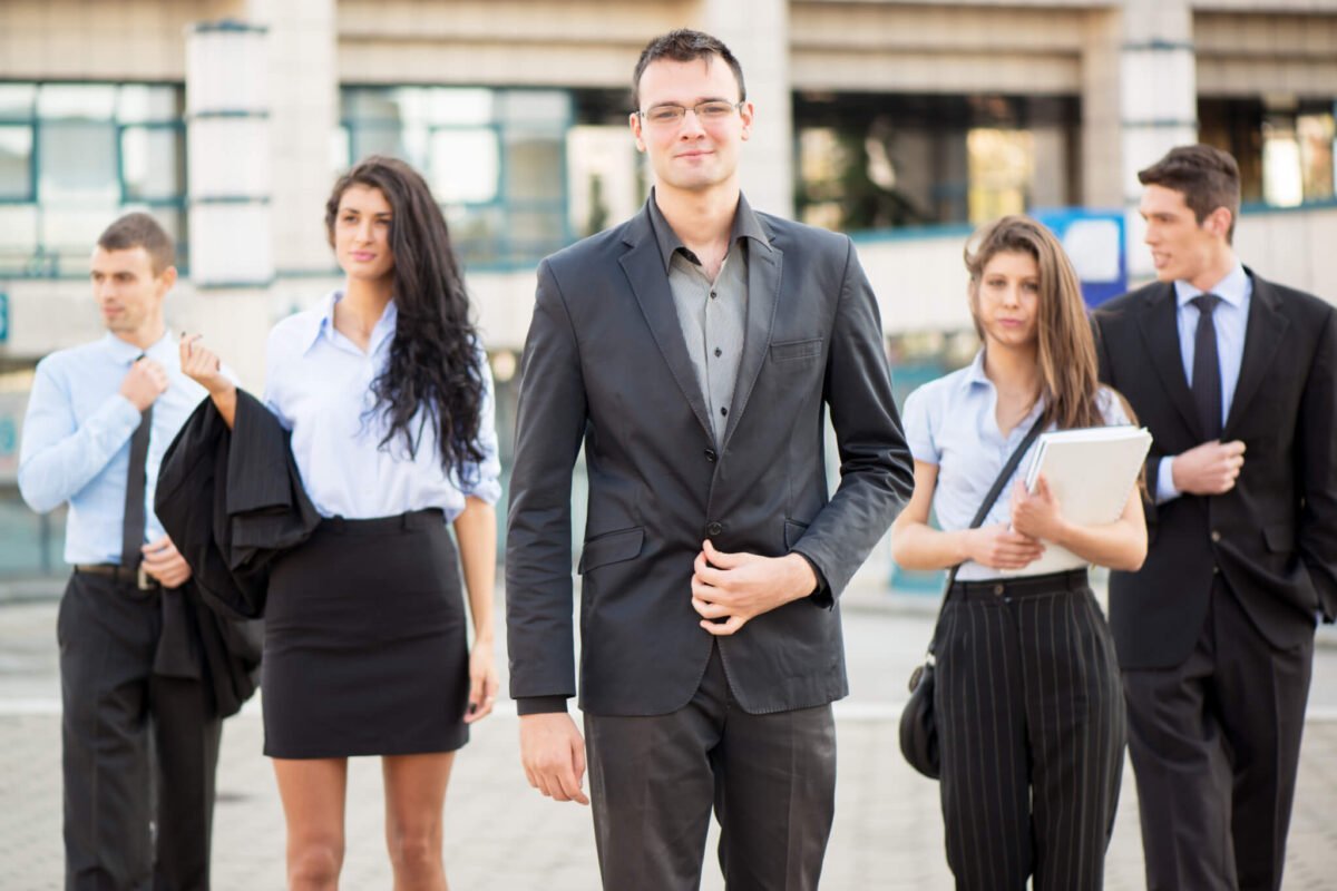 young businessman with four colleagues walking 