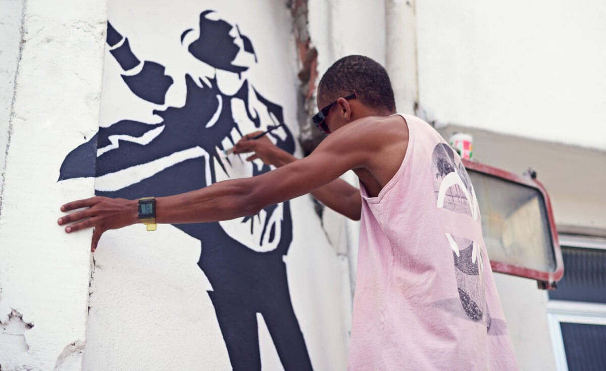 Creative expression. a young graffiti artist painting a design on a wall