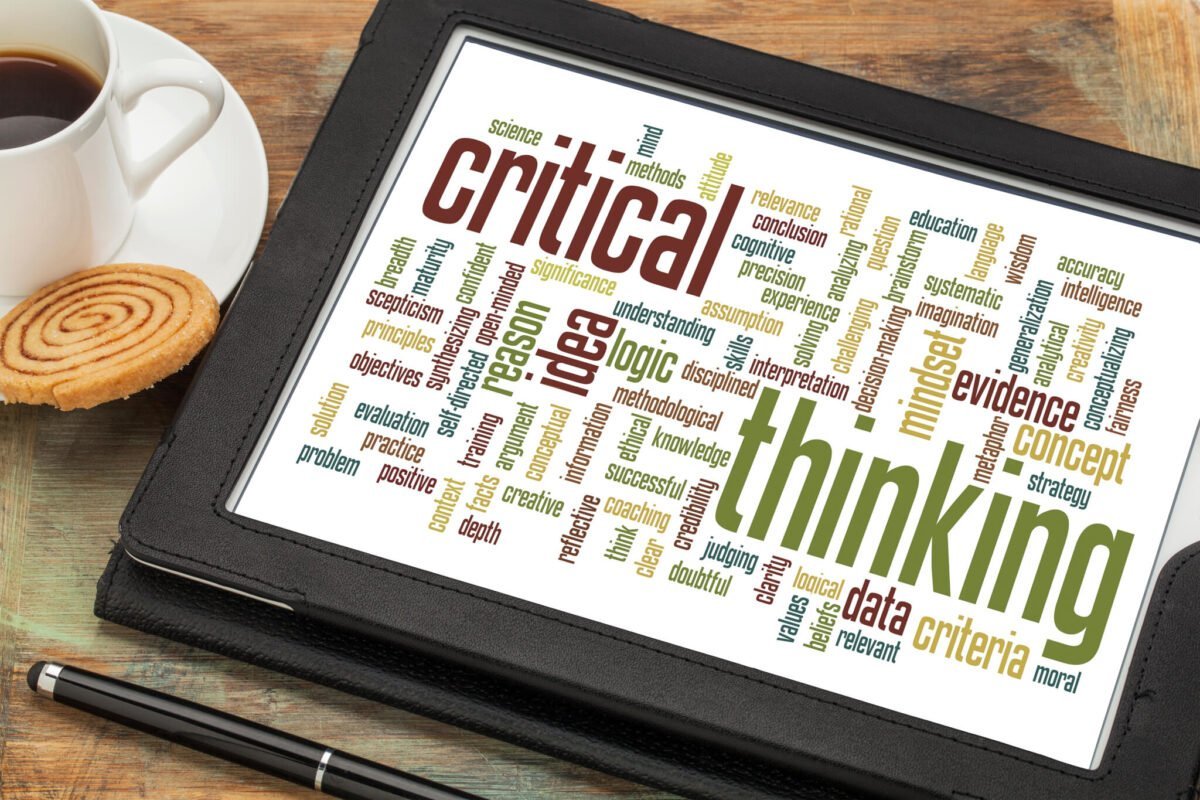 critical thinking word cloud on a digital tablet with a cup of coffee
