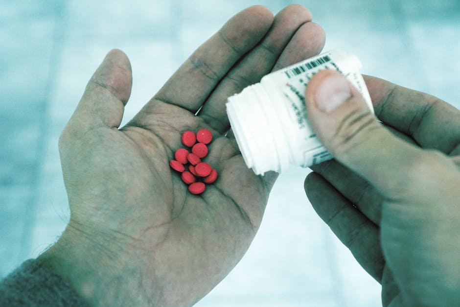 red opioid pills in hand