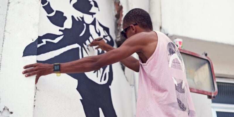 Creative expression. a young graffiti artist painting a design on a wall