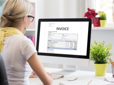 Woman checking business invoices on a computer