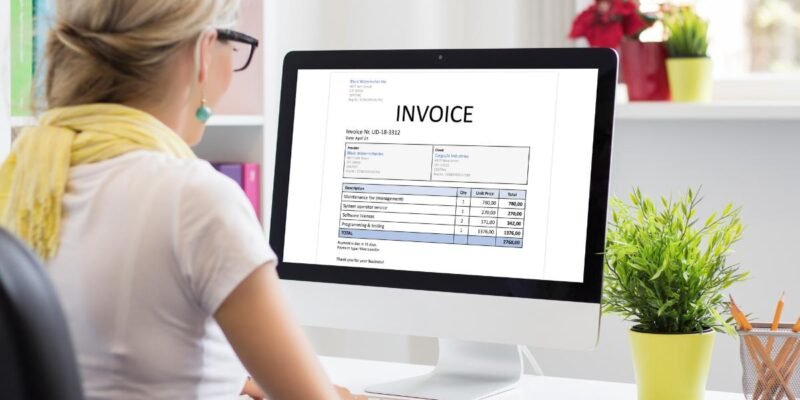 Woman checking business invoices on a computer