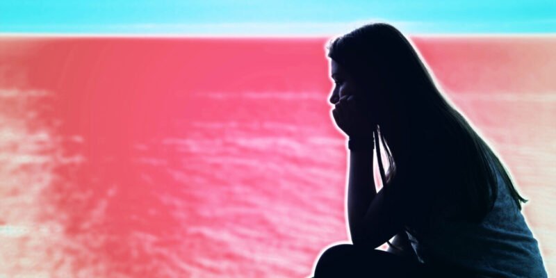 black silhouette of girl next to a red sea. stigma against mental health.
