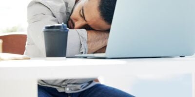 The ADHD burnout is real. a young man taking a nap at work in a modern office