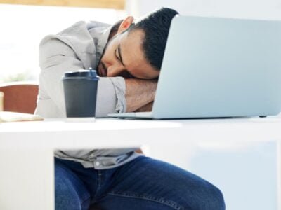 The ADHD burnout is real. a young man taking a nap at work in a modern office