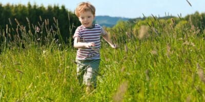 Boy running down a meadow to show autism elopement