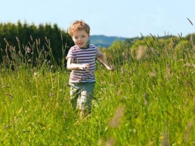 Boy running down a meadow to show autism elopement