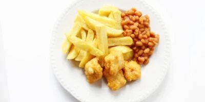 chicken nuggets chips and beans on a white plate is a classic autism safe food