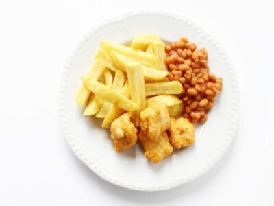 chicken nuggets chips and beans on a white plate is a classic autism safe food