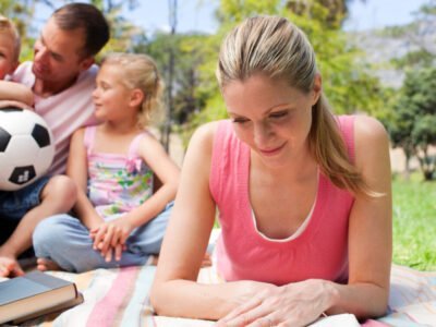 Concentrated mother reading at a picnic with her family