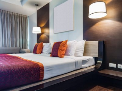 Red pillow on double bedroom with white compression bedsheet and lamp light