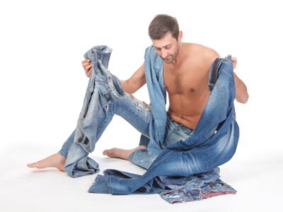 shirtless man with executive dysfunction deciding what jeans to wear