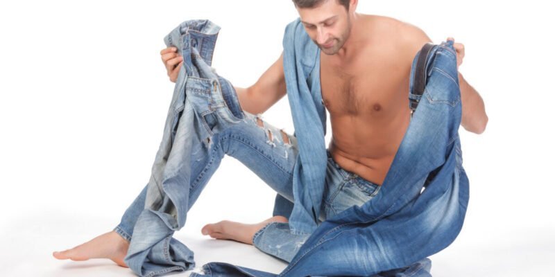 shirtless man with executive dysfunction deciding what jeans to wear