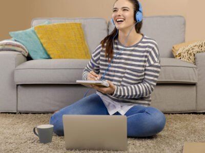 young girl with headphones on smiling while studying to music