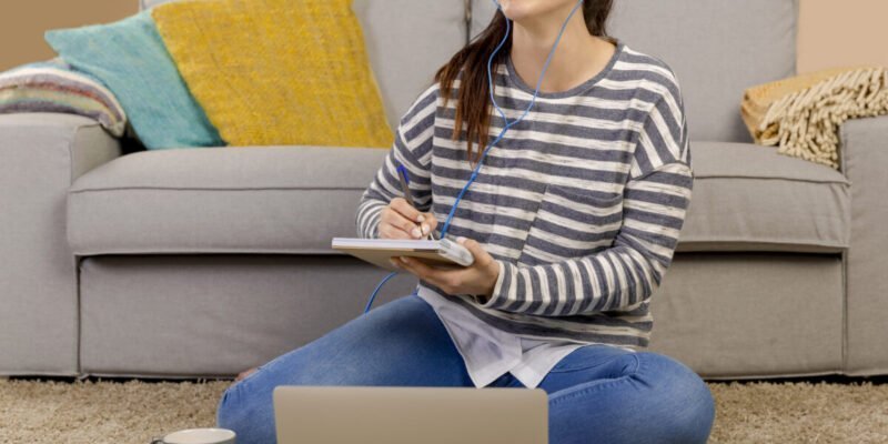 young girl with headphones on smiling while studying to music