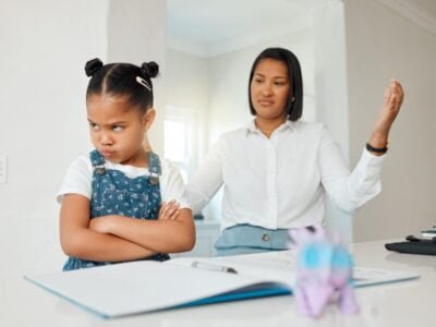 Kids can be so stubborn. Shot of a young mother looking frustrated while helping her daughter with homework at home.