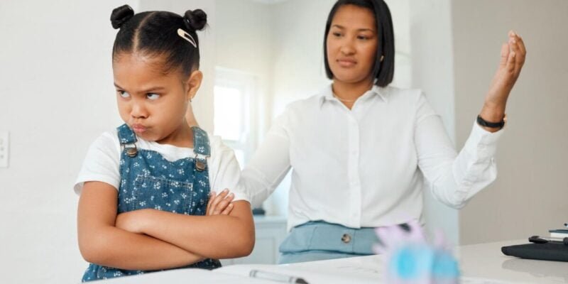 Kids can be so stubborn. Shot of a young mother looking frustrated while helping her daughter with homework at home.