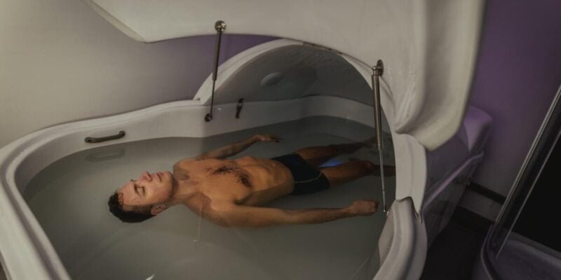 Relaxed man is floating in a sensory deprivation tank. He is very relaxed. Wellness and Spa concept.