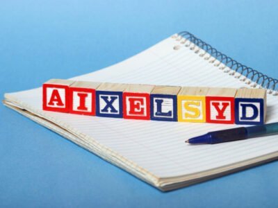 wooden letter blocks on white paper with blue background. letter blocks spell dyslexia incorrectly.